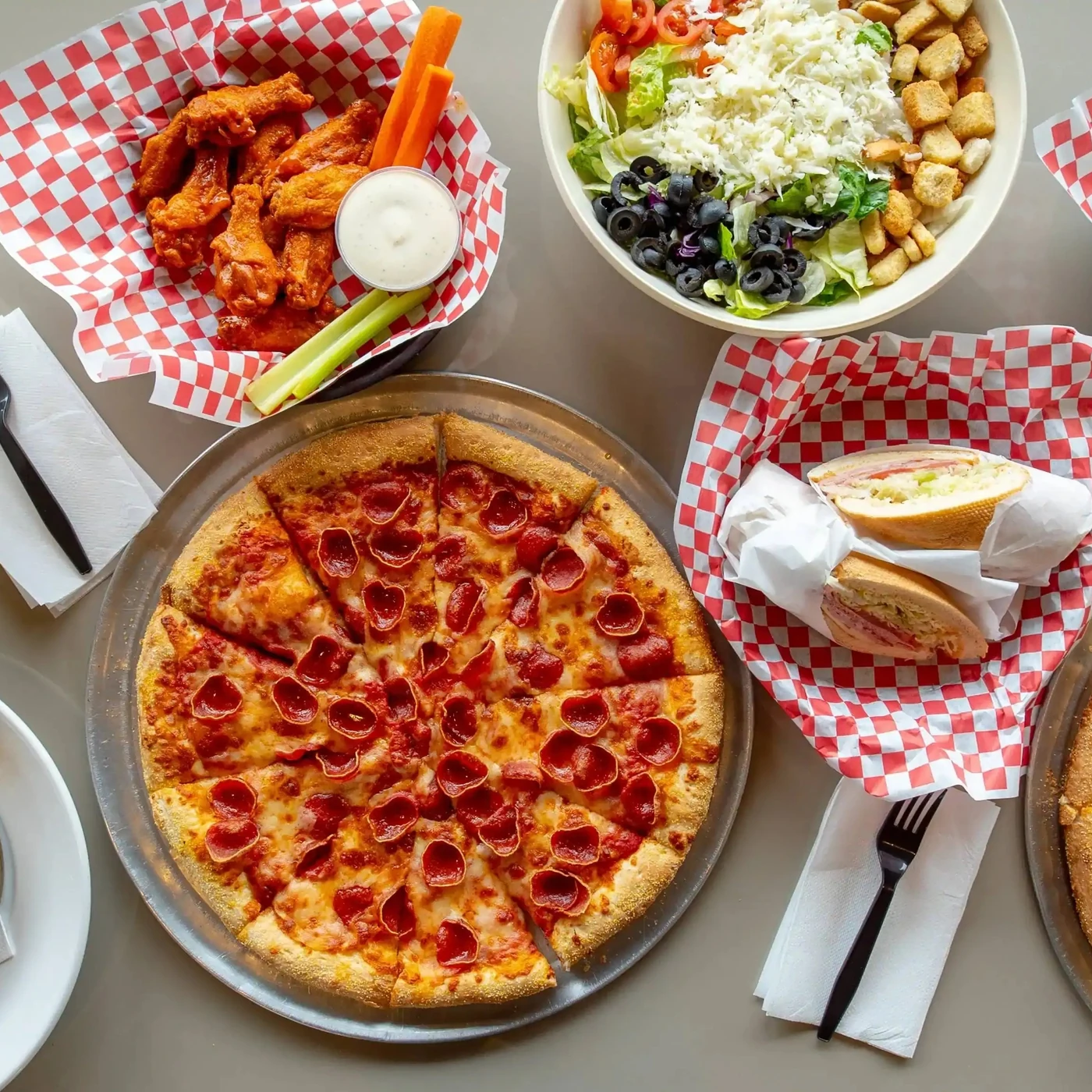 Pizza, wings, salads and subs spread out at Basile's 2 For 1 Pizza & Pasta in Beaumont, AB